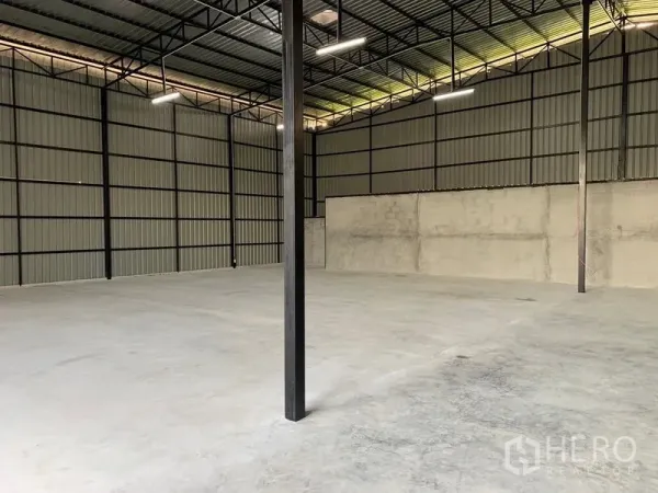 货栈 出租在Khan Na Yao, Bangkok - 宽敞仓库一角，金属墙板、钢柱与大面积混凝土地坪。