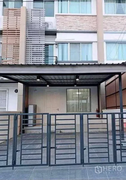 联排别墅 出租在Bang Kapi, Bangkok - 现代三层联排别墅外立面，带顶棚车位与金属围栏。