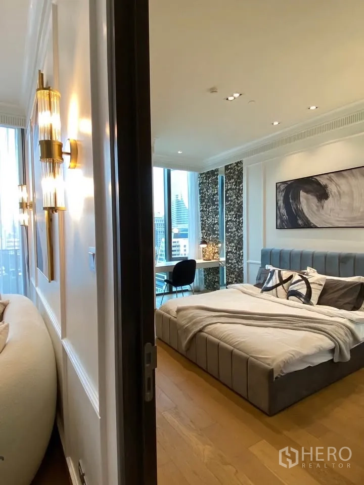 Condominium for rent in Pathum Wan, Bangkok - Entrance view to the bedroom showing wood floors, statement lighting, and large windows.