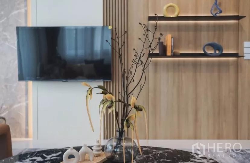 Detached House for rent in Bang Phli, Samut Prakan - Living room TV on feature wall with wood shelves and decorative vase.