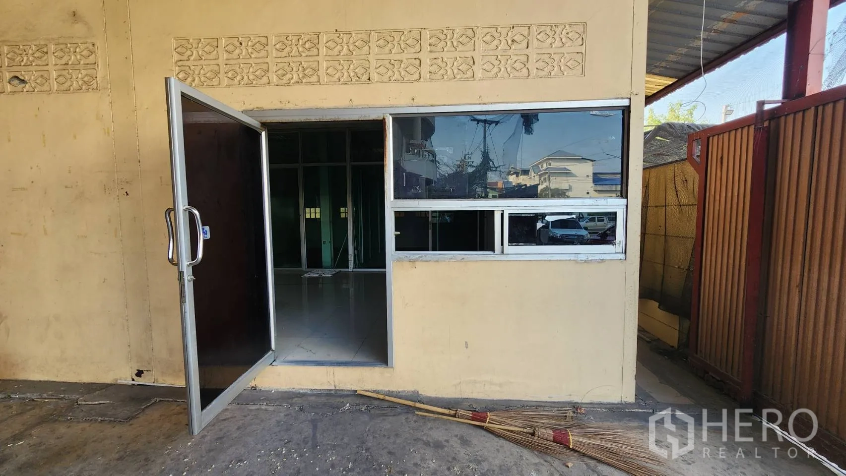 货栈 出租在Nonthaburi - 一层办公室入口，配玻璃窗与金属门。