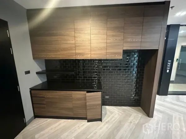 Office Space for rent - Built-in pantry with walnut cabinetry, black subway tile backsplash and dark stone countertop.