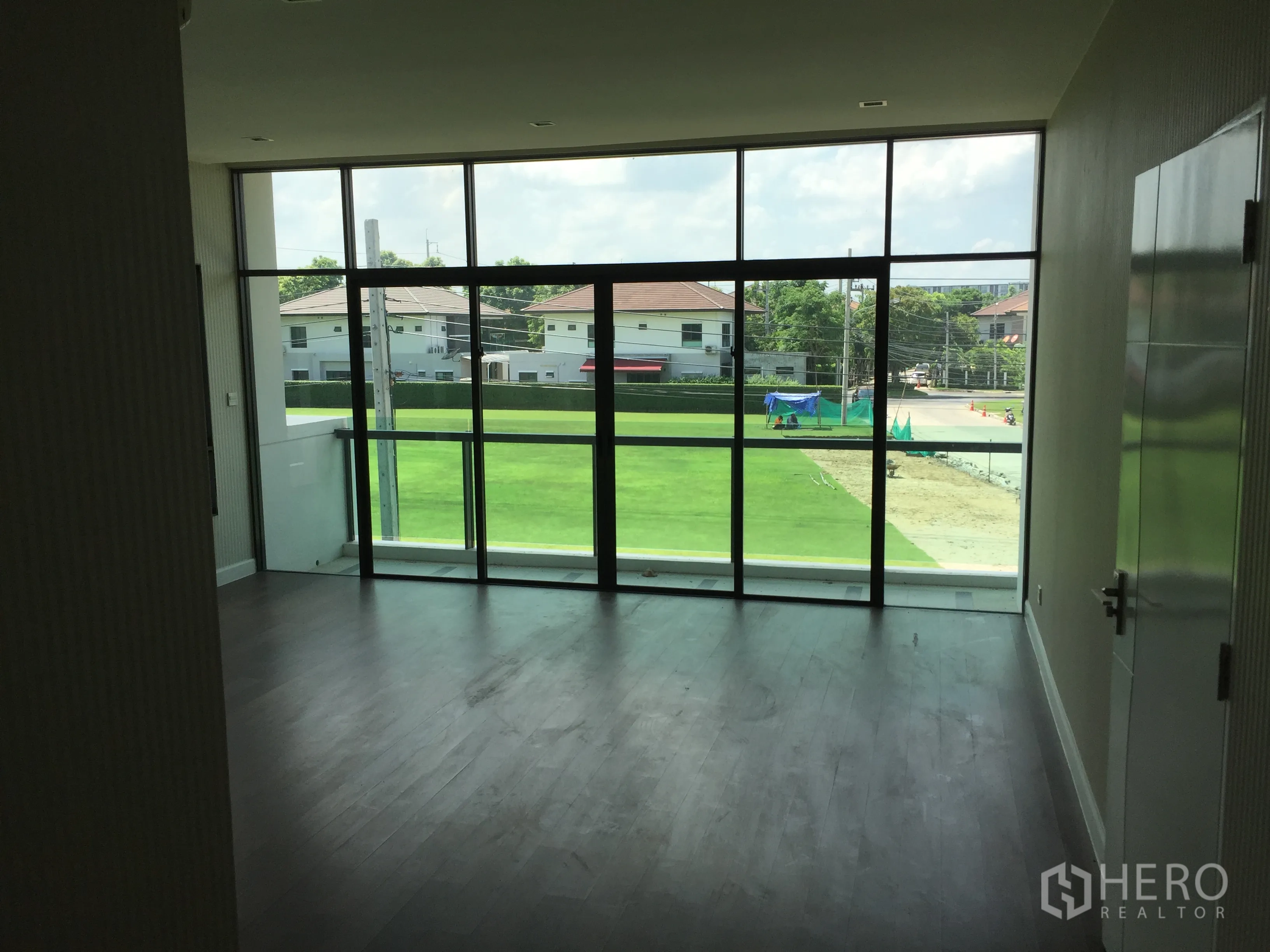 Detached House for rent or sale in Prawet, Bangkok - Spacious master suite with full-height glazing overlooking a manicured lawn.