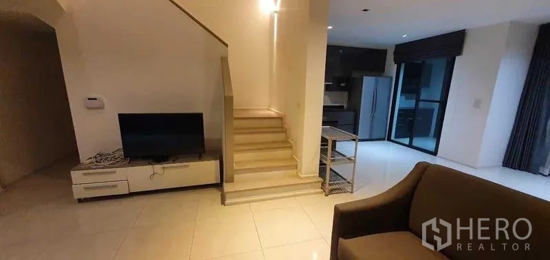 独立式住宅 出租在Prawet, Bangkok - 起居区连通楼梯与厨房，带电视柜