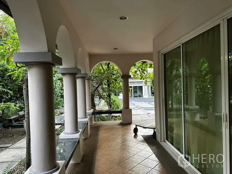 Detached House for sale in Bang Khun Thian, Bangkok - Covered terrace with arches and columns beside sliding glass doors facing the garden.