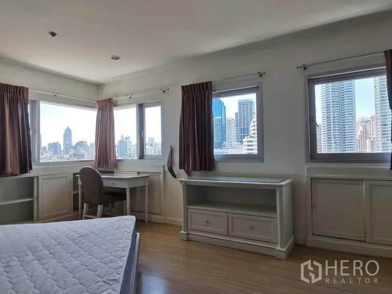 คอนโด ให้เช่าในKhlong Toei, Bangkok - ห้องนอนมุมอาคาร มีหน้าต่างหลายบาน โต๊ะทำงานบิวท์อิน และวิวตึกเมือง