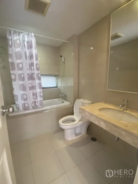 คอนโด ให้เช่าในPathum Wan, Bangkok - ห้องน้ำโทนอบอุ่นพร้อมอ่างอาบน้ำฝักบัว เคาน์เตอร์อ่างล้างหน้า และโถสุขภัณฑ์