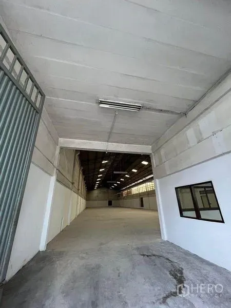 Warehouse for rent in Khlong Toei, Bangkok - Drive-in entrance leading into a spacious warehouse hall with high ceiling.