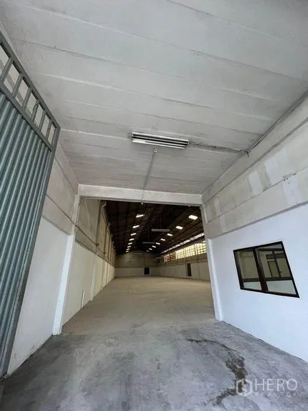 Warehouse for rent in Khlong Toei, Bangkok - Drive-in entrance leading into a spacious warehouse hall with high ceiling.