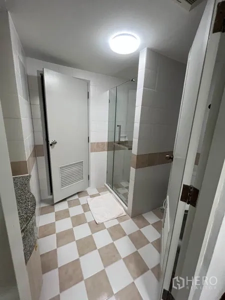 公寓 出租或出售在Watthana, Bangkok - 浴室带玻璃淋浴间，墙地砖为白米色拼接。