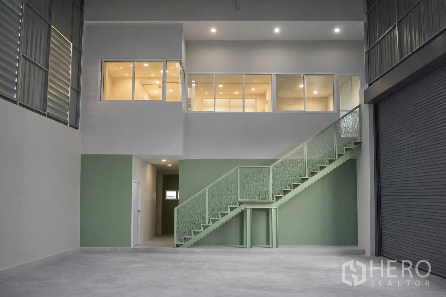 Warehouse for rent in Bang Kapi, Bangkok - Warehouse interior with metal staircase to mezzanine offices, glass windows and a roller shutter.