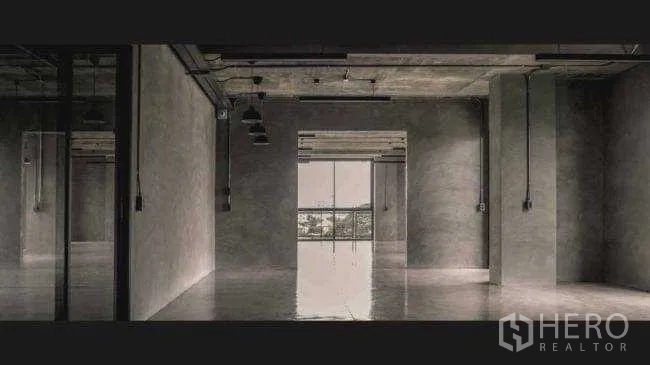 Office Space for rent or sale in Lak Si, Bangkok - Expansive open-plan floor with concrete ceiling, track lighting, and window wall at the end.