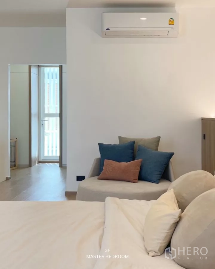 ทาวน์เฮาส์ ให้เช่าในSuan Luang, Bangkok - ห้องนอนมาสเตอร์กว้าง มีเตียง โซฟาขนาดเล็ก และเครื่องปรับอากาศผนัง