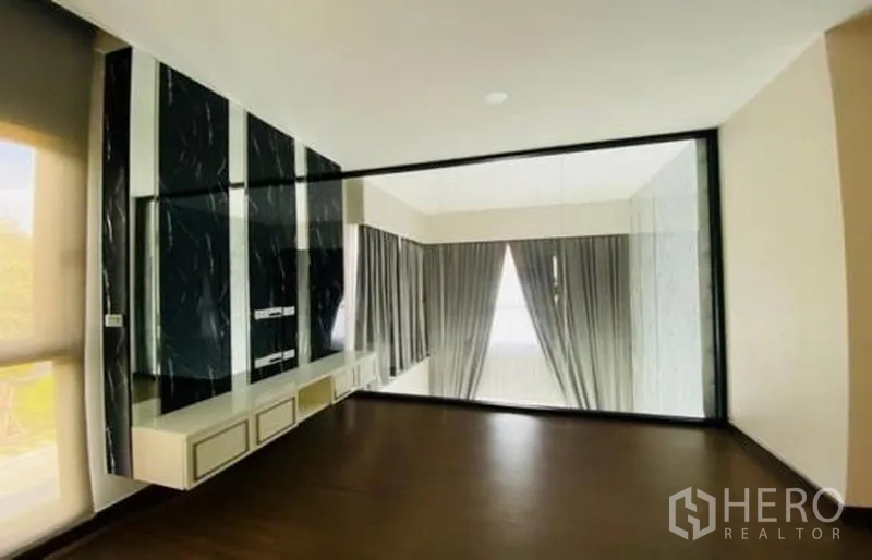 Detached House for sale in Bang Phli, Samut Prakan - Upper room with dark wood flooring and glass partition overlooking below.