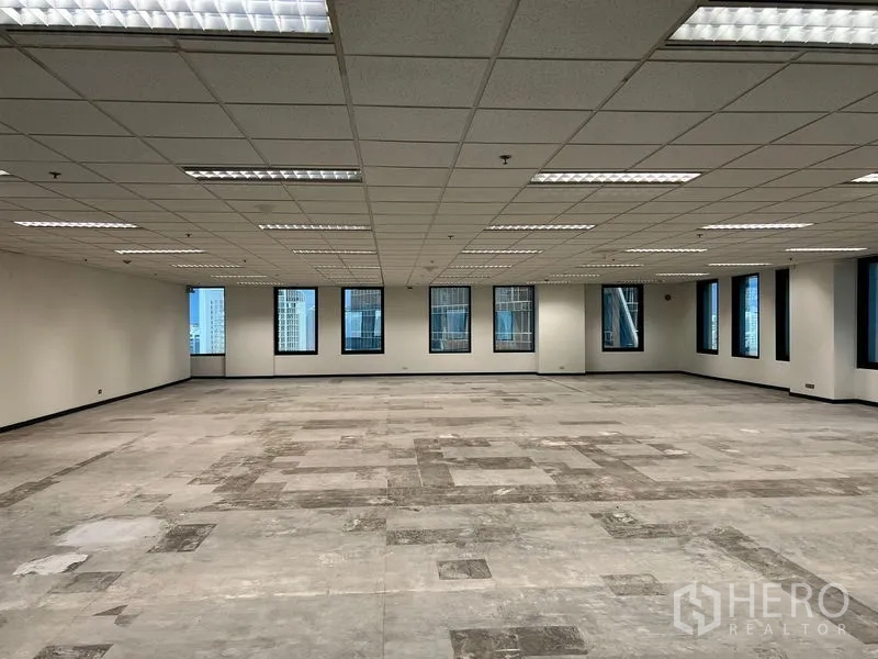 สำนักงาน ให้เช่าในKhlong Toei, Bangkok - โถงสำนักงานโล่ง พื้นลายปะ หน้าต่างรอบด้านมองเห็นตึกสูงกรุงเทพฯ ใต้เพดานแบบกริด