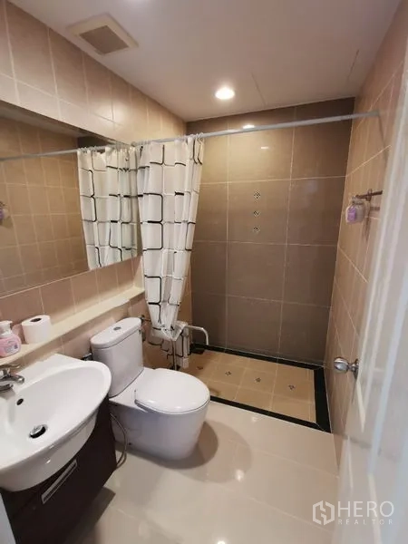 联排别墅 出租在Wang Thonglang, Bangkok - 紧凑卫生间，带洗手台、马桶与帘隔淋浴区的瓷砖空间。