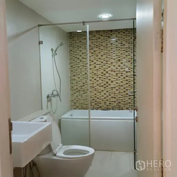 Condominium for rent in Watthana, Bangkok - Modern bathroom with glass enclosure, bathtub and mosaic feature wall in an Ekkamai Bangkok condominium.