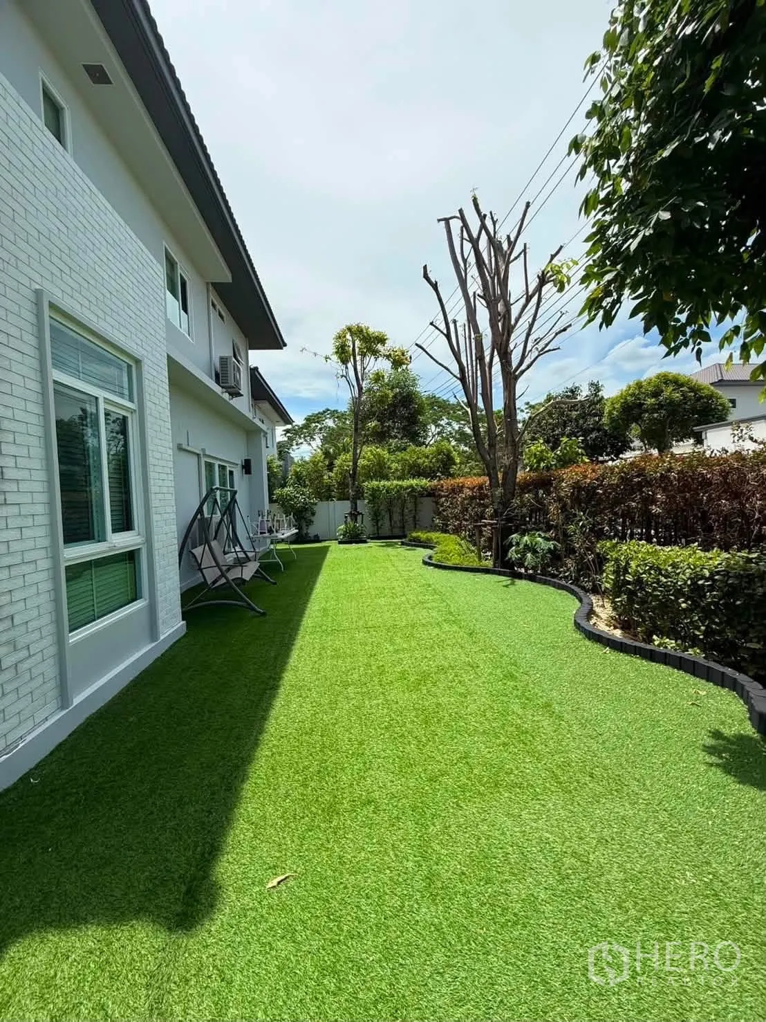 Detached House for rent in Bang Phli, Samut Prakan - Side yard with long green lawn along the house.