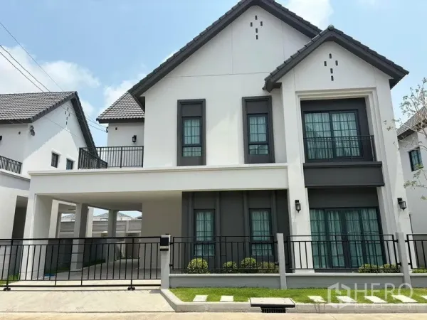 Detached House for rent in Bang Phli, Samut Prakan - Front elevation of the detached house showing gate, carport and symmetrical windows.