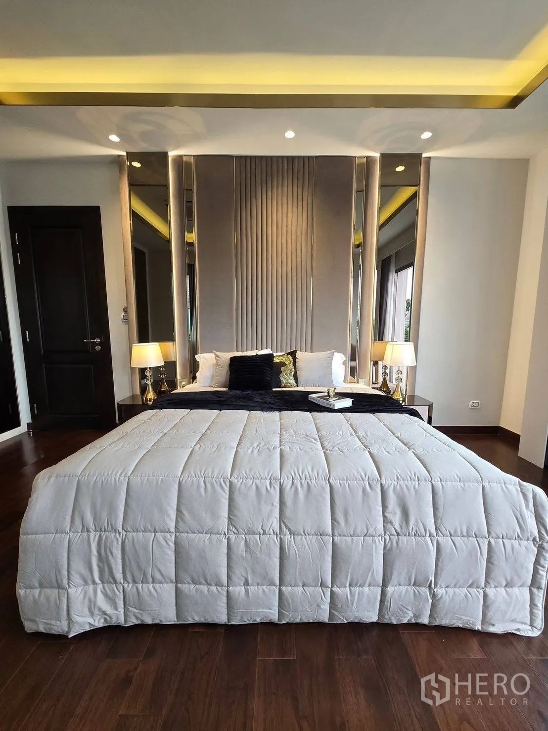 Detached House for rent or sale in Bang Phli, Samut Prakan - Front view of bed with upholstered headboard, bedside lamps and soft ambient ceiling lighting.