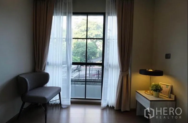 คอนโด ให้เช่าในPathum Wan, Bangkok - มุมนั่งอ่านหนังสือข้างหน้าต่างสูง ผ้าม่านโปร่ง มองเห็นวิวต้นไม้เมือง