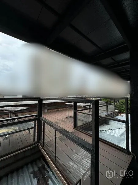 店屋 出租在Phaya Thai, Bangkok - 半覆盖屋顶露台，金属栏杆与木质地台，适合摆放座位。