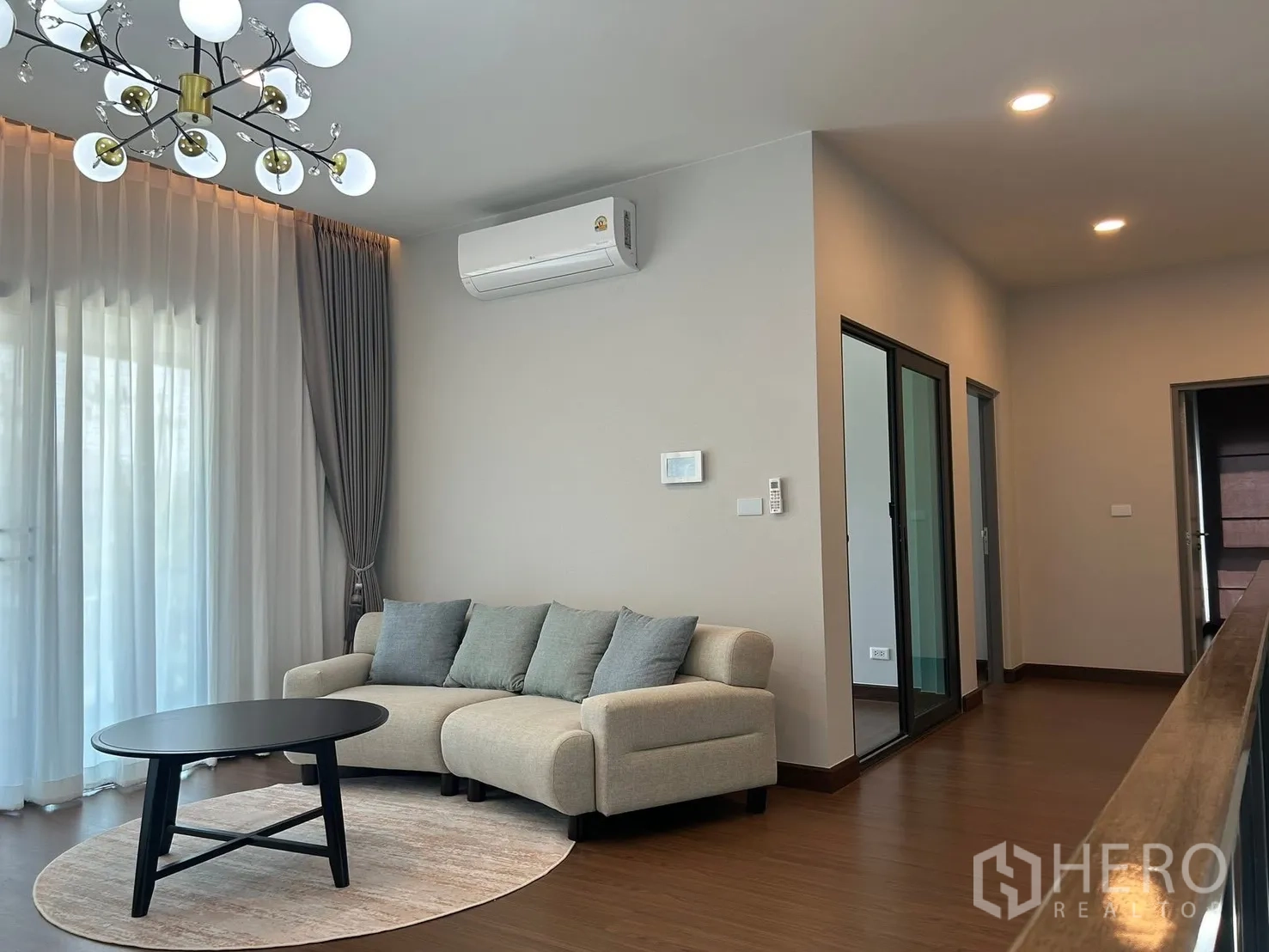 独栋房屋 for rent in Bang Phli, Samut Prakan - 二楼起居区配沙发、圆茶几、吊灯及推拉玻璃门。