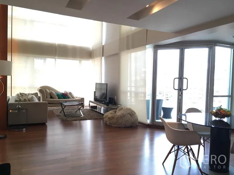 คอนโด ให้เช่าในPathum Wan, Bangkok - ห้องนั่งเล่นโปร่ง แสงธรรมชาติ โซฟา ทีวี และผ้าม่านสูง