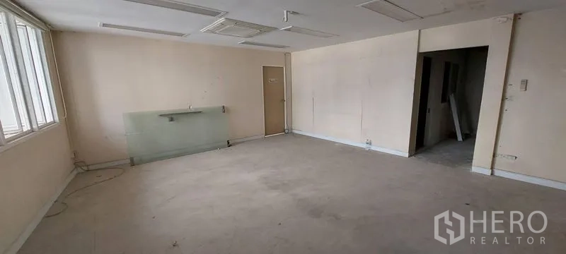 Shophouse for sale - Empty office floor with large windows and neutral walls.