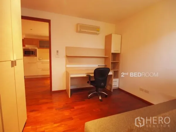คอนโด ให้เช่าในPathum Wan, Bangkok - ห้องนอนที่สองมีโต๊ะทำงาน เก้าอี้ล้อ พื้นไม้ อมอุ่น มองเห็นพื้นที่ครัว