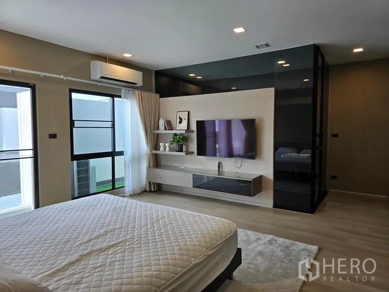 ทาวน์เฮาส์ ให้เช่า - ห้องนอนใหญ่กว้างพร้อมทีวีติดผนัง ชั้นวาง และตู้เสื้อผ้ากระจก