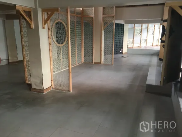 零售空间 出租在Khlong Toei, Bangkok - 开放式零售室内空间，瓷砖地面与木质网格隔断，便于分区陈列。