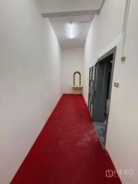 Office Space for rent in Khlong Toei, Bangkok - Narrow hallway with red carpet and a small console table.