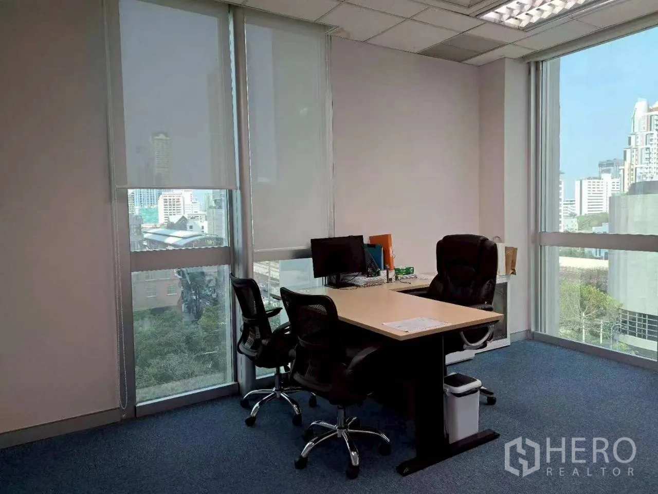 Office Space for rent in Sathon, Bangkok - Private office with L-shaped desk, executive chairs and large windows with roller blinds.