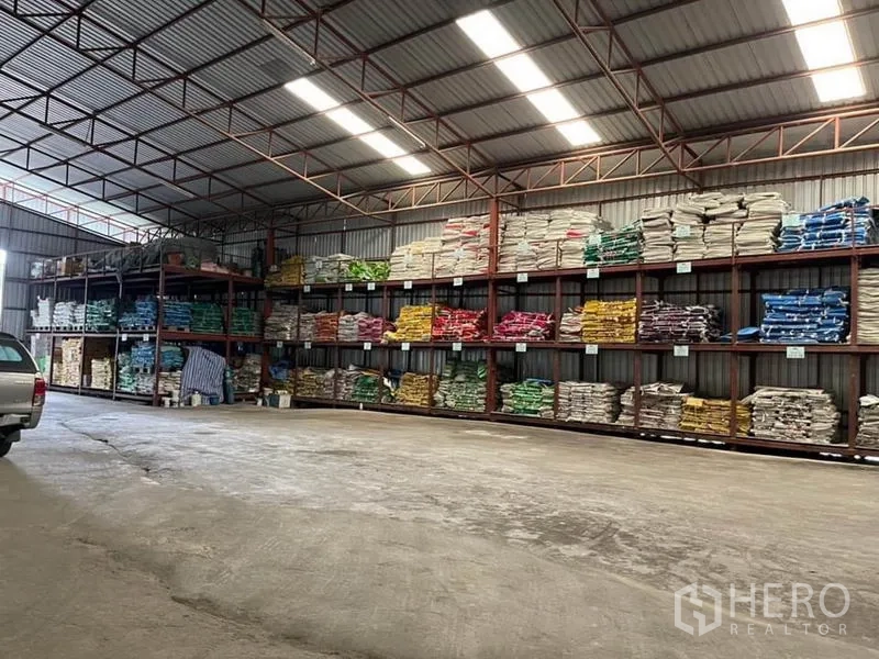 货栈 出售在Lam Luk Ka, Pathum Thani - 墙面整排钢制货架，堆满彩色袋装货物。