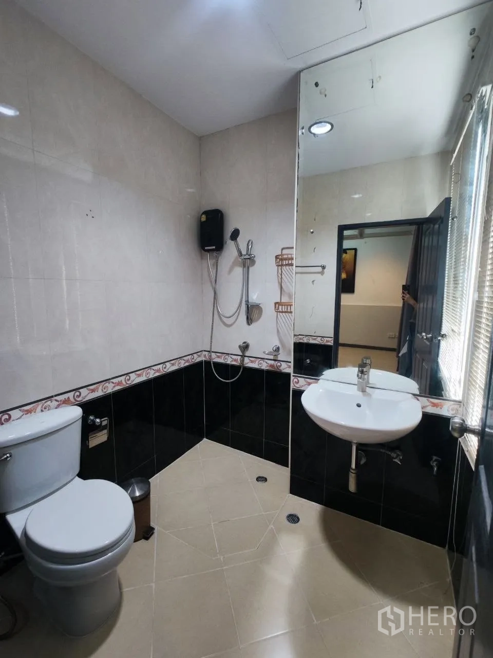 家庭办公室 for rent in Bang Na, Bangkok - 瓷砖浴室，带大镜子、坐便器、手持花洒和洗手盆。