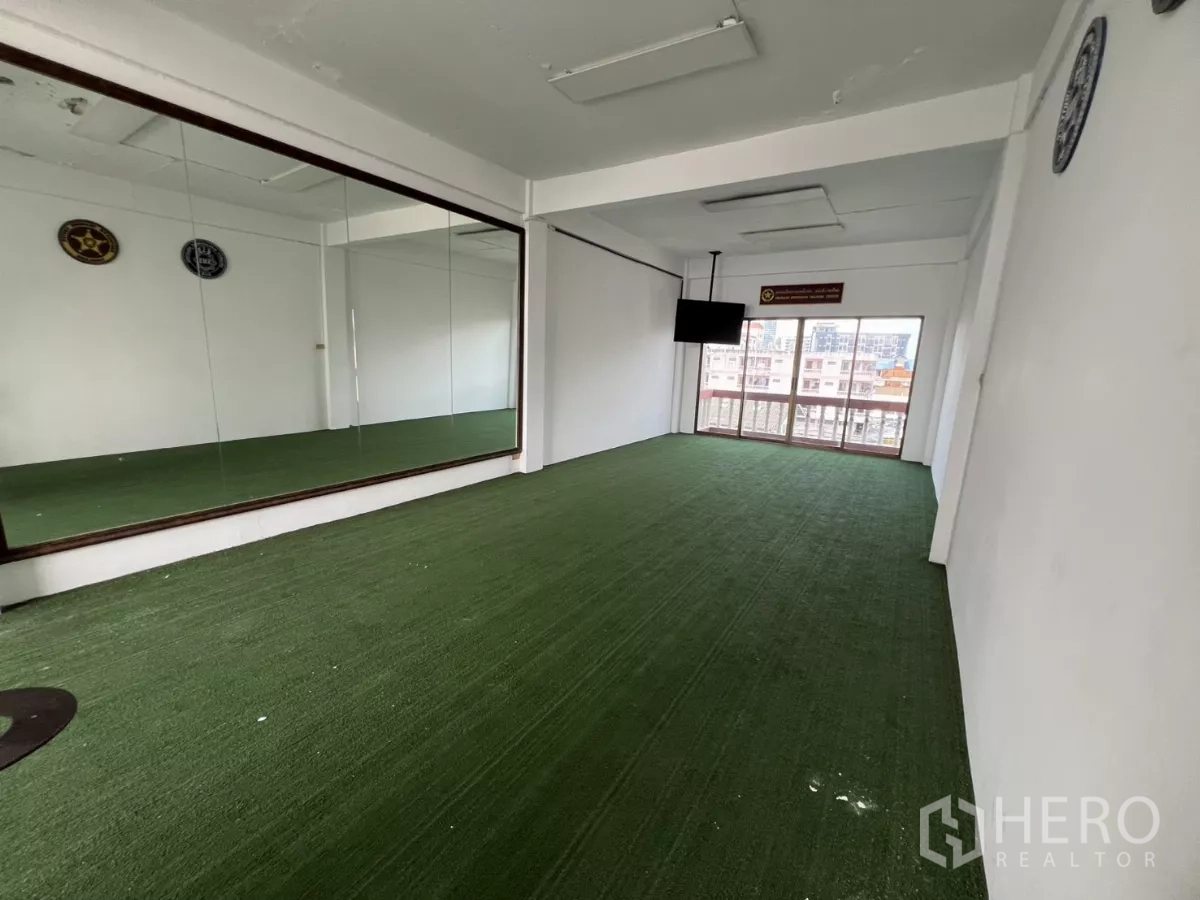 店屋 出租在Watthana, Bangkok - 楼上工作室，绿色地毯、整面镜及通往阳台的推拉门。