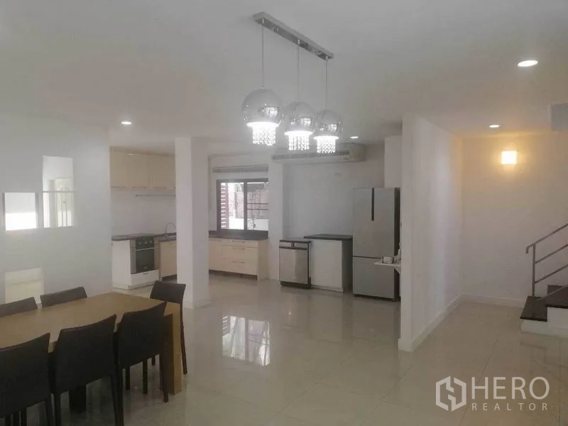 Townhouse for rent in Wang Thonglang, Bangkok - Bright open kitchen and dining space with pendant lights and modern appliances.