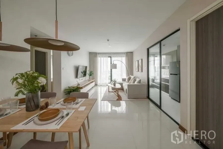 คอนโด ให้เช่าในKhlong San, Bangkok - โซนทานอาหารและนั่งเล่นแบบโอเพ่น พื้นเงา ครัวกั้นกระจกบานเลื่อน และประตูกระจกออกระเบียง