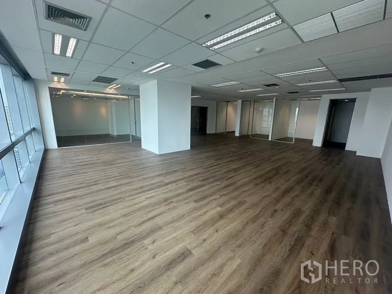 สำนักงาน ให้เช่า - มุมมองอีกด้านของสำนักงานแบบเปิด เห็นหน้าต่างสูงเต็มบานและห้องกระจก.