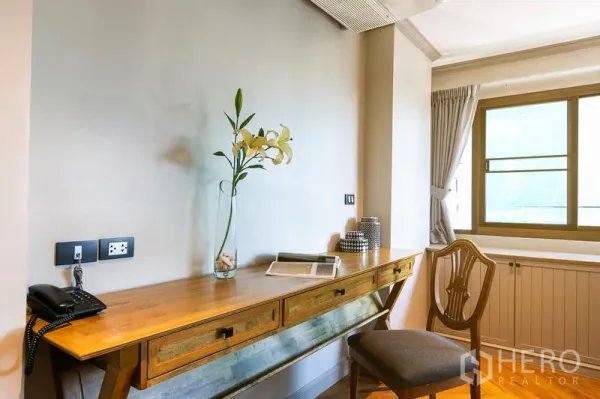 อพาร์ทเมนท์ ให้เช่าในWatthana, Bangkok - มุมทำงานสว่างด้วยโต๊ะไม้ยาว แจกันดอกไม้ และเก้าอี้ ข้างหน้าต่างมีผ้าม่าน