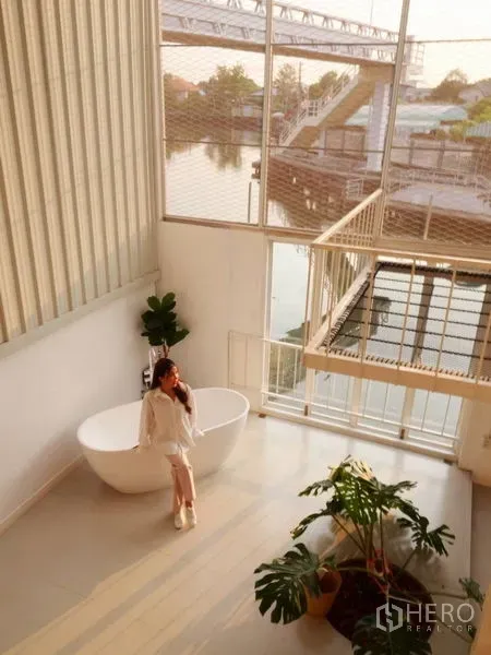 ทาวน์เฮาส์ ให้เช่าในKhlong Toei, Bangkok - โถงโล่งสไตล์ลอฟต์ มีอ่างอาบน้ำ ไม้ประดับ และวิวสายน้ำในทาวน์เฮ้าส์พระโขนง