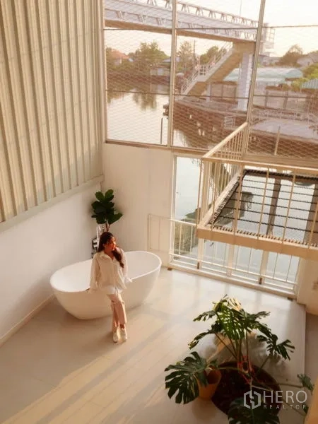 ทาวน์เฮาส์ ให้เช่าในKhlong Toei, Bangkok - โถงโล่งสไตล์ลอฟต์ มีอ่างอาบน้ำ ไม้ประดับ และวิวสายน้ำในทาวน์เฮ้าส์พระโขนง