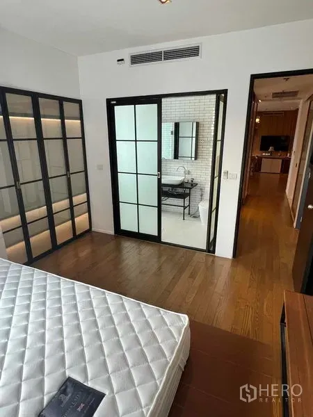 คอนโด ให้เช่าในWatthana, Bangkok - ห้องนอนสว่างเชื่อมสู่ห้องน้ำในตัวผ่านประตูกระจกบานเลื่อน กระเบื้องสีขาว