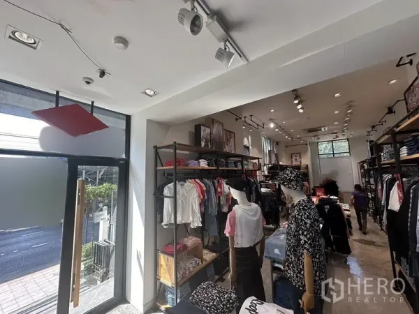 พื้นที่ขายปลีก ให้เช่าในPhra Khanong, Bangkok - ภายในร้านค้าติดถนนสว่างไสว ประตูกระจก ไฟราง ชั้นวางเสื้อผ้า และพื้นคอนกรีตขัดมัน