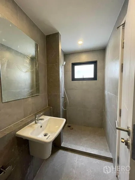 ทาวน์เฮาส์ ให้เช่าในPrawet, Bangkok - ห้องน้ำพร้อมอ่างล้างหน้า กระจก และพื้นที่อาบน้ำยกพื้น ใต้ไฟเพดาน