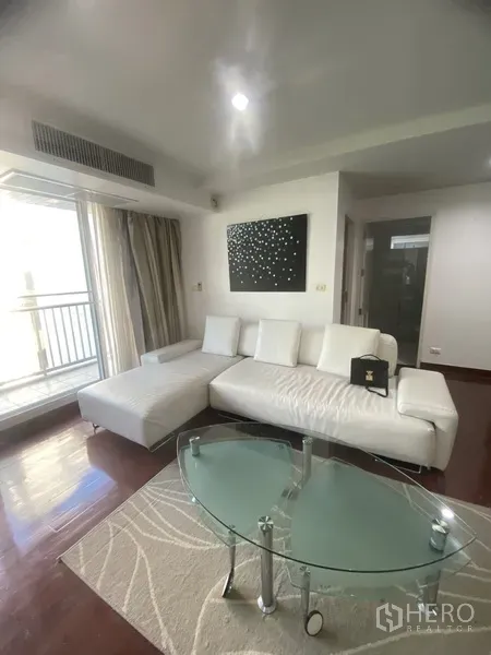 คอนโด ให้เช่าในWatthana, Bangkok - ห้องนั่งเล่นสว่าง โซฟาเข้ามุมสีขาว โต๊ะกระจก ประตูกระจกออกระเบียง พื้นไม้