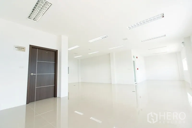 Warehouse for rent in Bang Bo, Samut Prakan - Open-plan office level with manager room door and polished tiled flooring.
