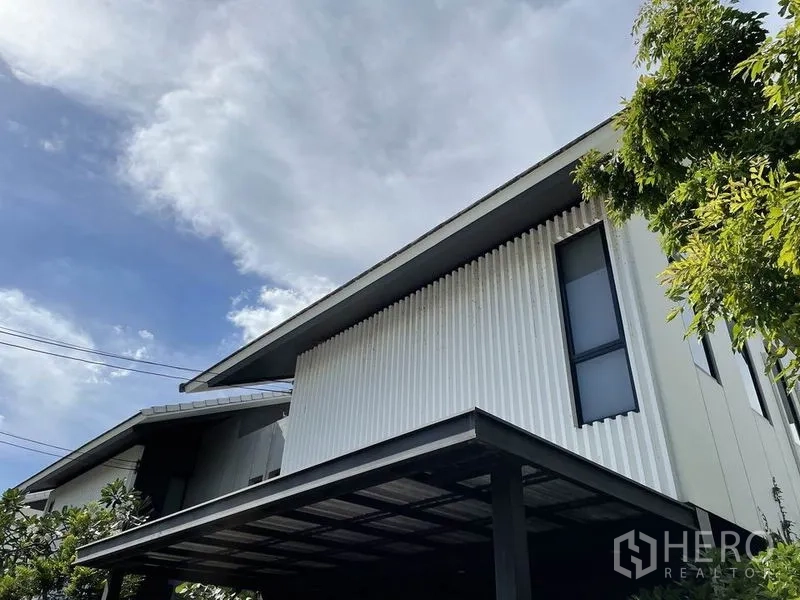 บ้าน ขายในSai Mai, Bangkok - รายละเอียดหน้าบ้านโมเดิร์นกับผนังริ้วโลหะและหลังคาที่จอดรถ