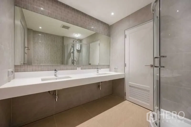 联排别墅 出售在Khlong Toei, Bangkok - 现代卫浴，双洗手台、超大镜面与玻璃淋浴间，浅色瓷砖。